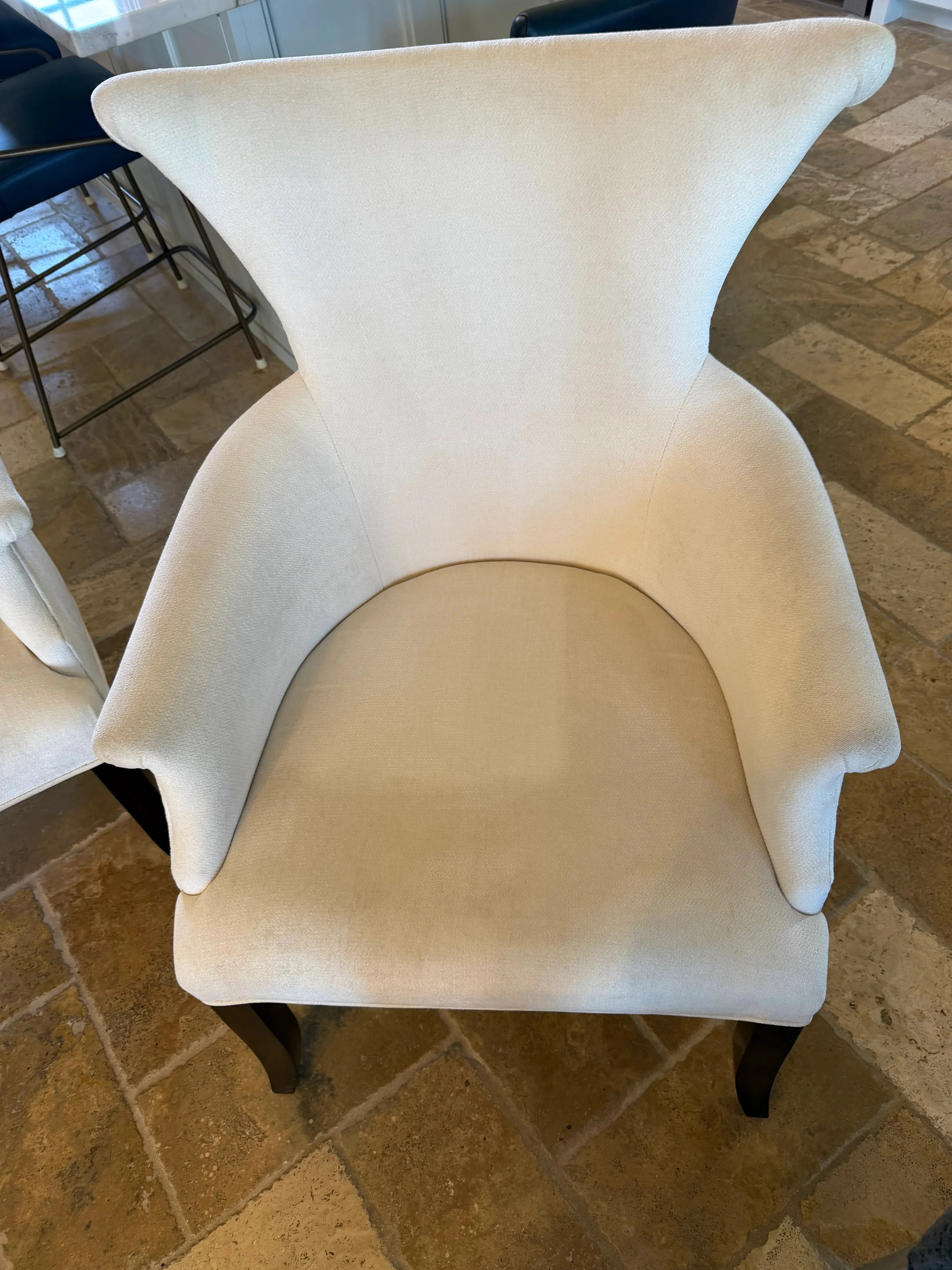 Cream wingback chair with cleaned upholstery on stone tile floor