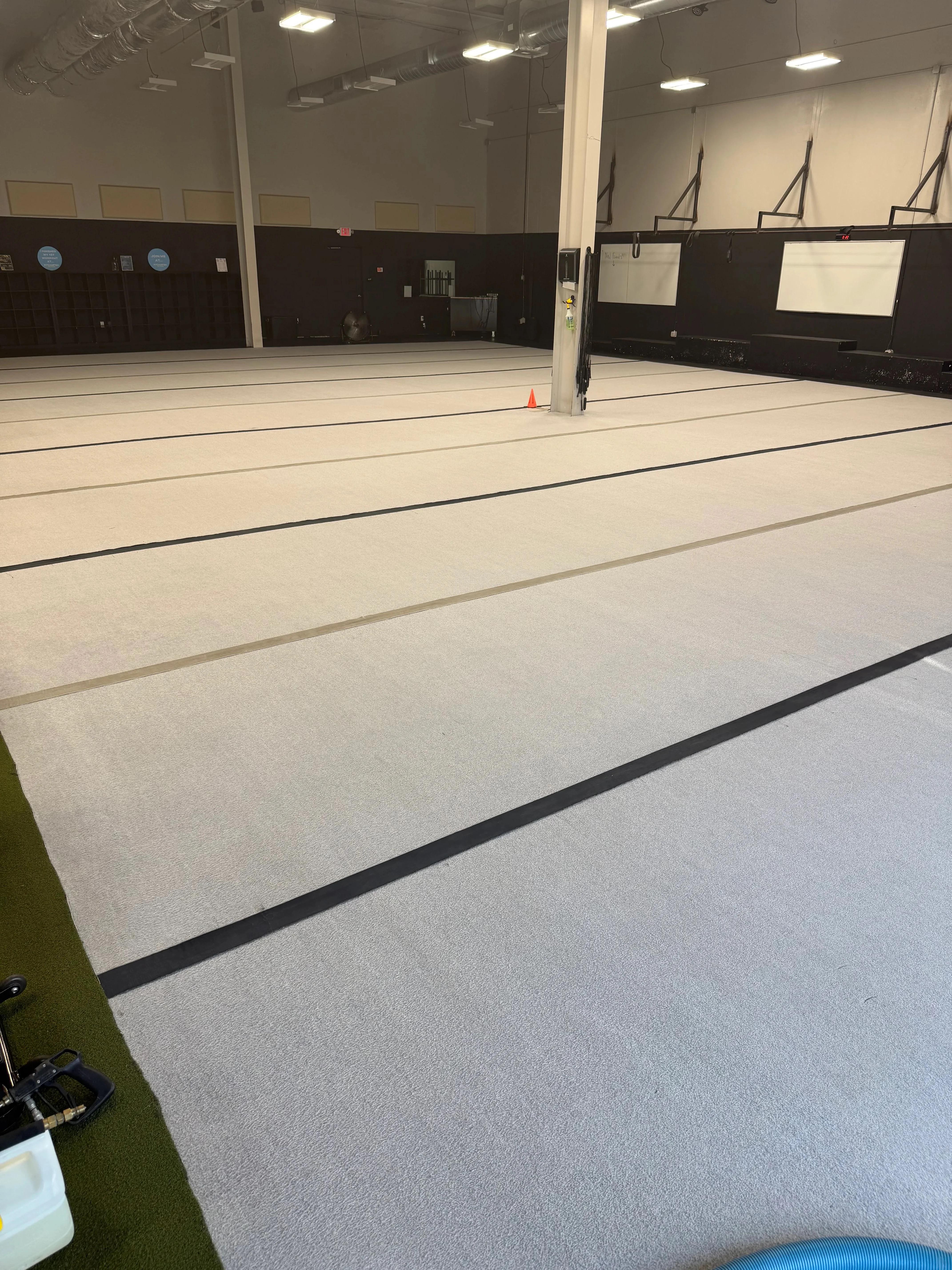 Light gray commercial carpet with black binding and seams in multi-court facility